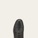 Black leather dress shoe on a light beige background