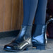 Dublin Black riding boots on a child wearing blue riding leggings on a barn floor.