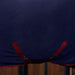A close-up of a dark navy blue fabric cooler, featuring burgundy surcingles and trim, hanging against a dark wooden background.
