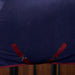 A close up of a navy cooler with burgundy surcingles crossed under the belly of a horse that is standing in a barm