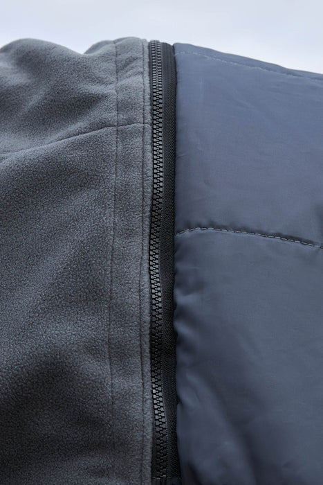 Close-up detail of a dark gray zippered Comfi Guard hood showing a textured fleece fabric on one side and a smooth quilted panel on the other.