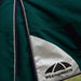 Close-up of a dark green Weatherbeeta horse blanket with navy and white piping, a white diagonal panel with the black Weatherbeeta logo, and a small Weatherbeeta brand patch near the top.