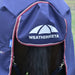 A navy blue and burgundy horse turnout blanket showing the tail flap and leg straps attached with silver metal claps featuring the WeatherBeeta logo in white on the front flap, shown on a horse outdoors.