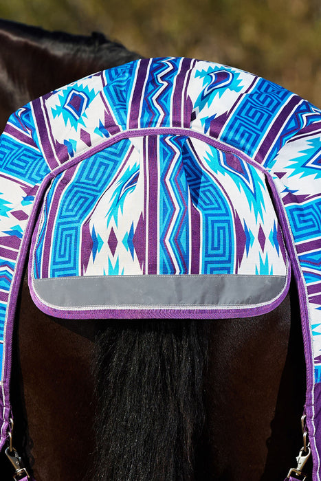 A close-up of a horse's rump and tail area wearing a patterned horse blanket or tack cover. The fabric has a geometric Southwestern-style print in blue, purple, and white, with a gray reflective strip along the front edge.