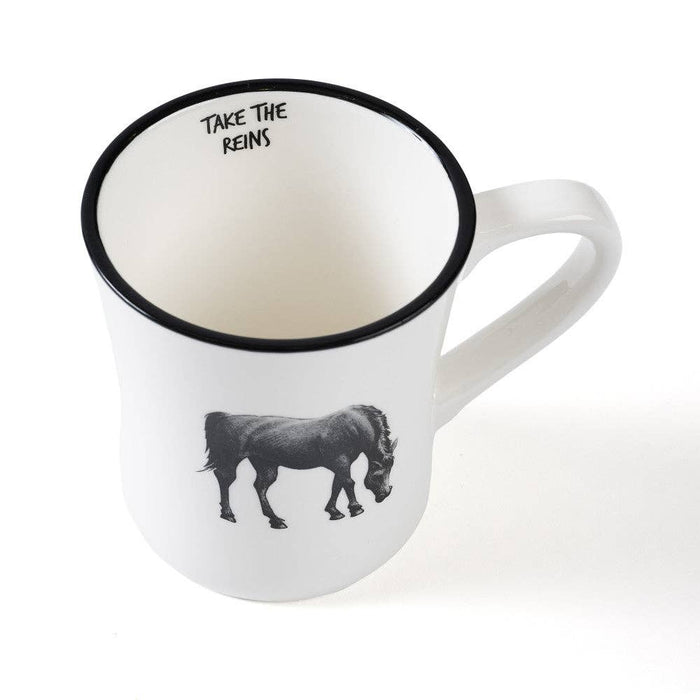 A white ceramic mug with a black rim, featuring a black illustration of a pony and the text 'TAKE THE REINS' printed inside the mug, set against a plain white background.