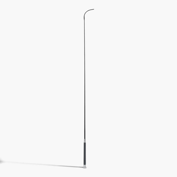 A 43 inch long dressage whip with a black woven fabric covered shaft and a gel grip handle with a  silver cap on a white background with a shadow of the whip.
