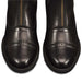 Close-up of black leather boots with a gold zipper on a white background