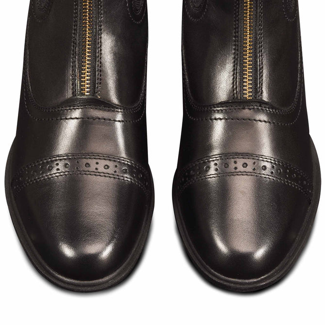 Pair of black leather paddock riding boots with gold zippers on a white background