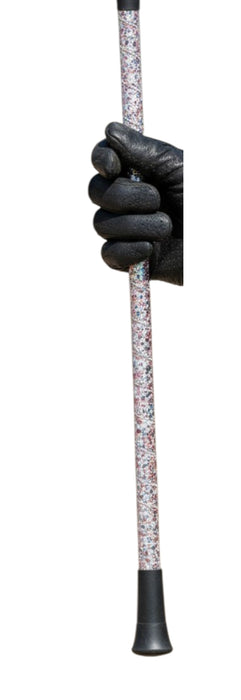 A close-up of a hand wearing a black glove holding the shaft of a riding crop with a speckled white handle and black rubber tips.