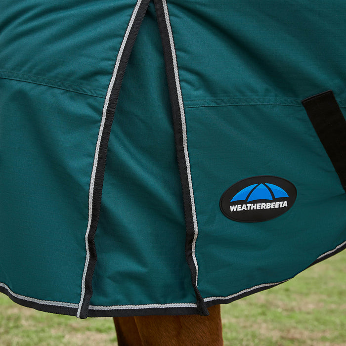 Close-up of a green horse blanket with Weatherbeeta logo on a grassy background