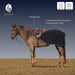 A brown horse stands in a stable-like setting wearing a black Equinavia saddle pad with a brown leather saddle. The image includes text callouts pointing to the anti-pill fleece and contouring around the hind quarters, plus two feature icons for weather resistance and breathability.
