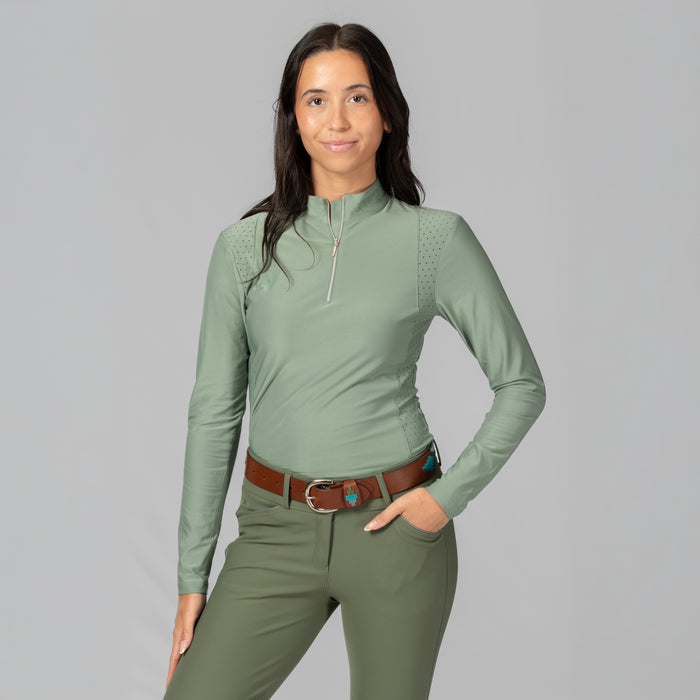 A women wearing a long-sleeve athletic quarter-zip top in a muted sage green color, featuring perforated side panels and a high mock neck collar, displayed on a mannequin torso against a plain grey background.
