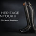 A single black Ariat tall riding boot shown on a dark studio background with promotional text reading 'NEW HERITAGE CONTOUR II' and 'Slimmer Fit, More Cushion.' The Ariat logo is visible on the right.