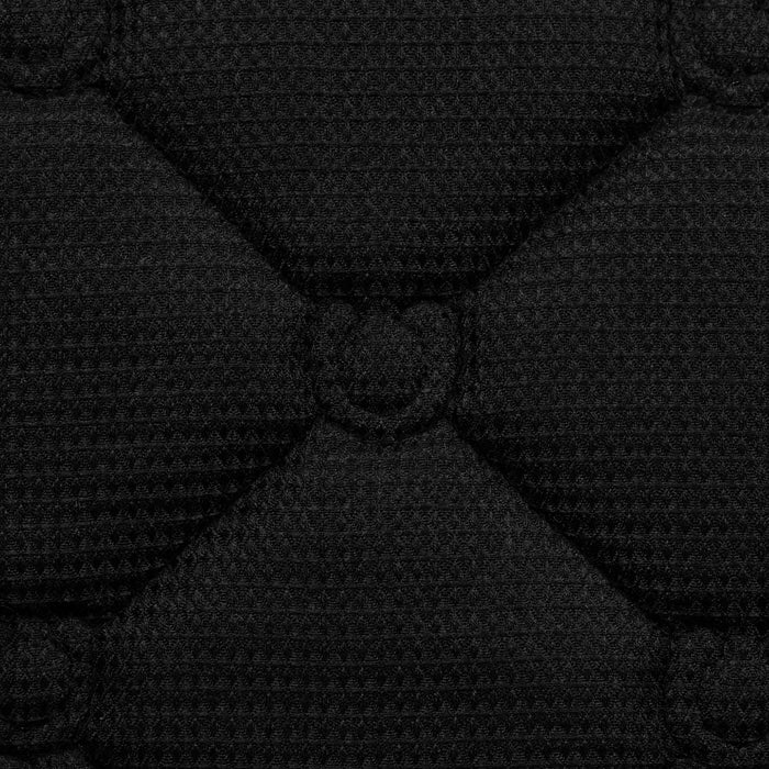 Close-up of a black quilted fabric texture with diamond-shaped stitching and a central stitched detail.