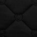 Close-up of a black quilted fabric texture with diamond-shaped stitching and a central stitched detail.